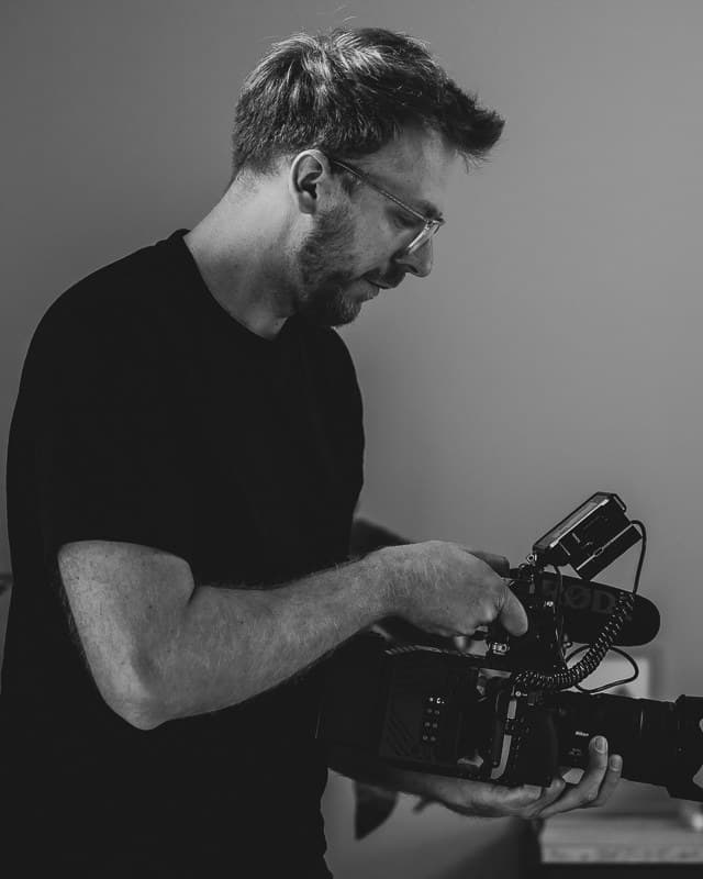 Dylan Dubois, founder of Agence Dubois, adjusting his camera during a shoot in a salon