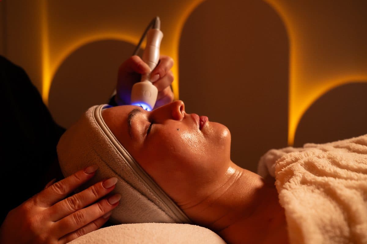 Client lying in a beauty salon treatment room under warm arched lighting