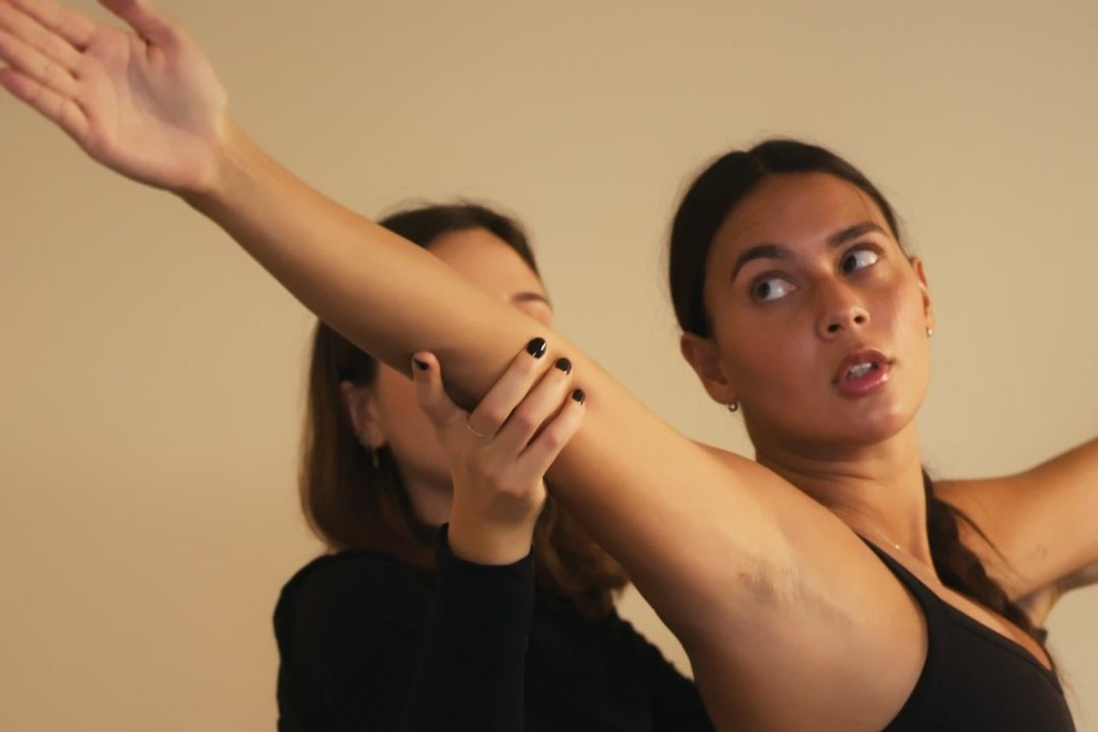 Une coach de L'Adresse Pilates corrige le mouvement de bras d'une élève pendant un cours privé