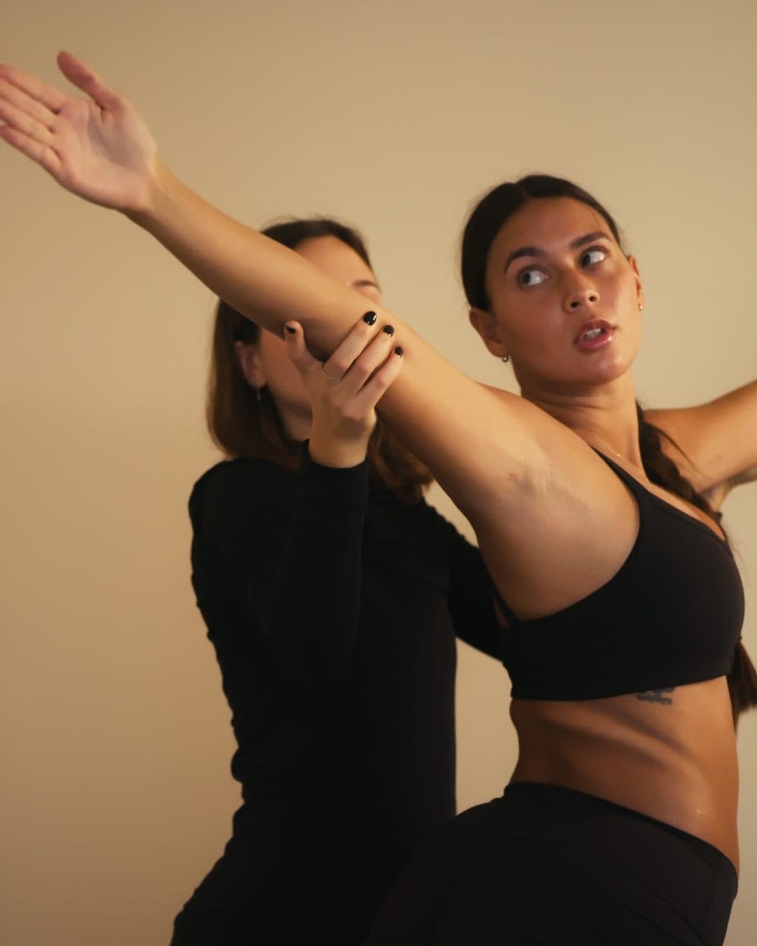 Une coach de L'Adresse Pilates corrige le mouvement de bras d'une élève pendant un cours privé